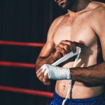 Boxing athlete men wrapping hand with boxing tape before wearing boxing gloves at gym