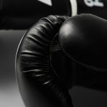 Pair of black boxing gloves on white background, closeup