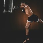 side view of muay thai fighter training with punching bag, action sport concept