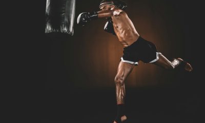 side view of muay thai fighter training with punching bag, action sport concept